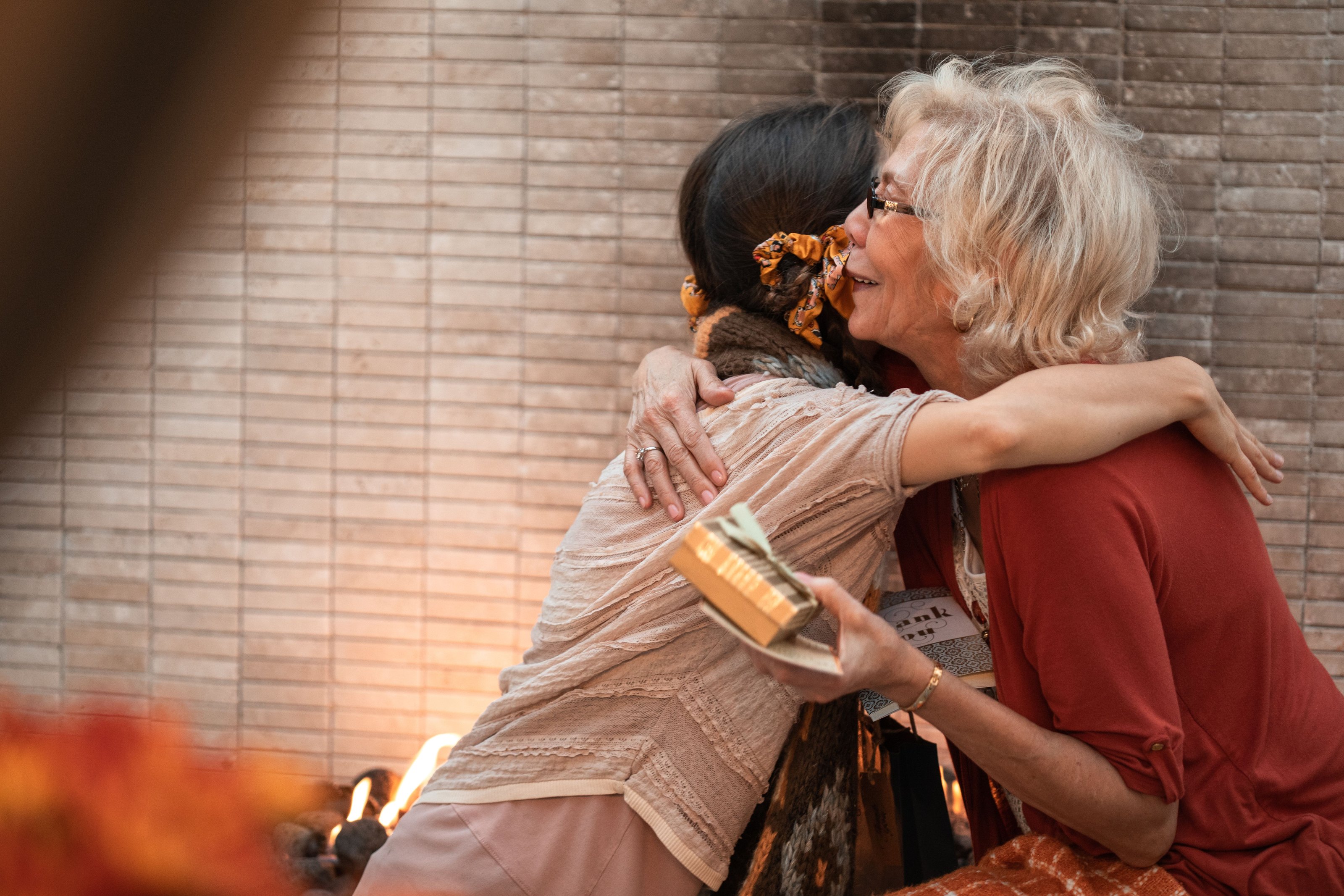 An older woman and a younger woman embracing warmly at home
